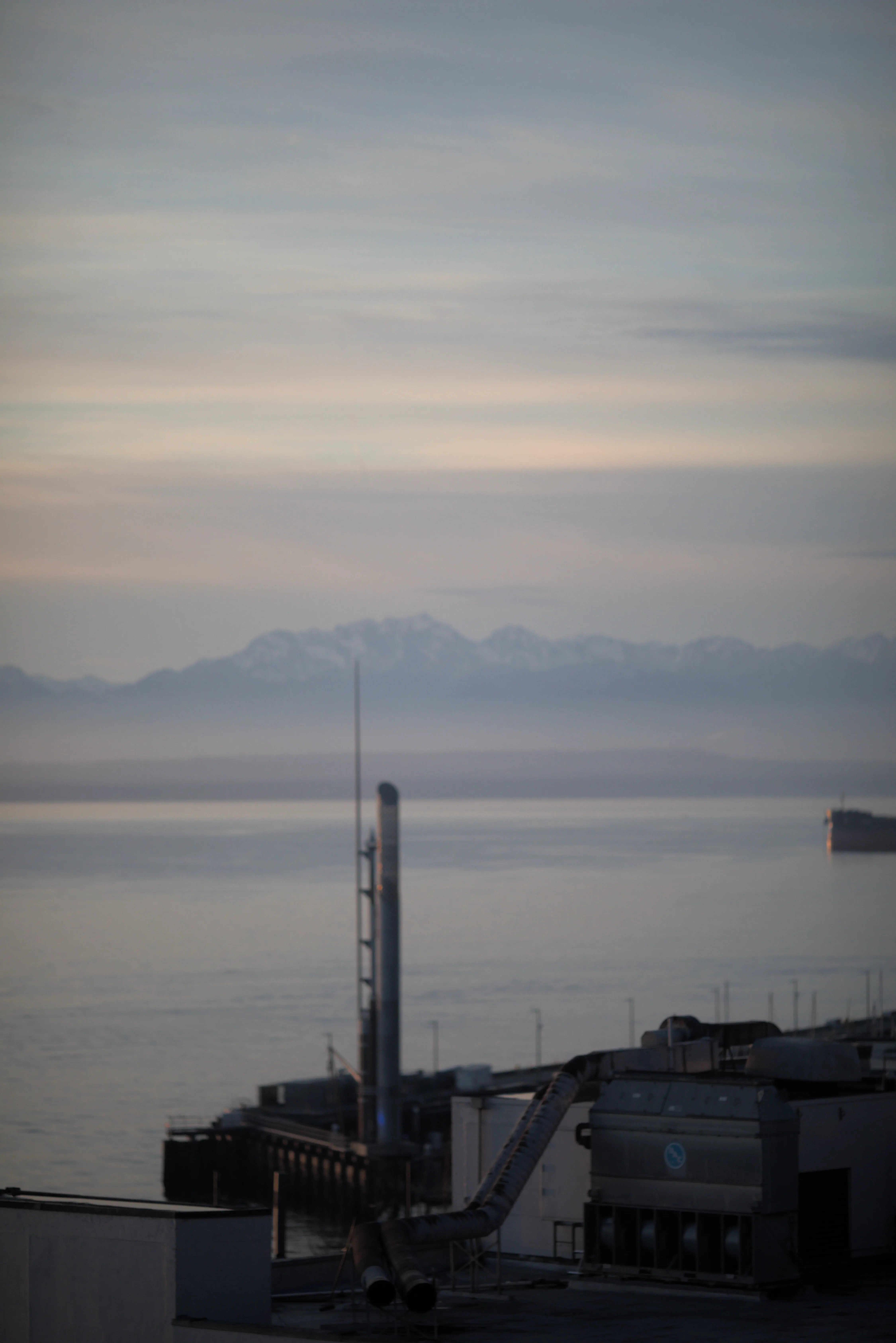 A ventalation system and a piece of a pier 66 appear in front of the mountains across The Sound