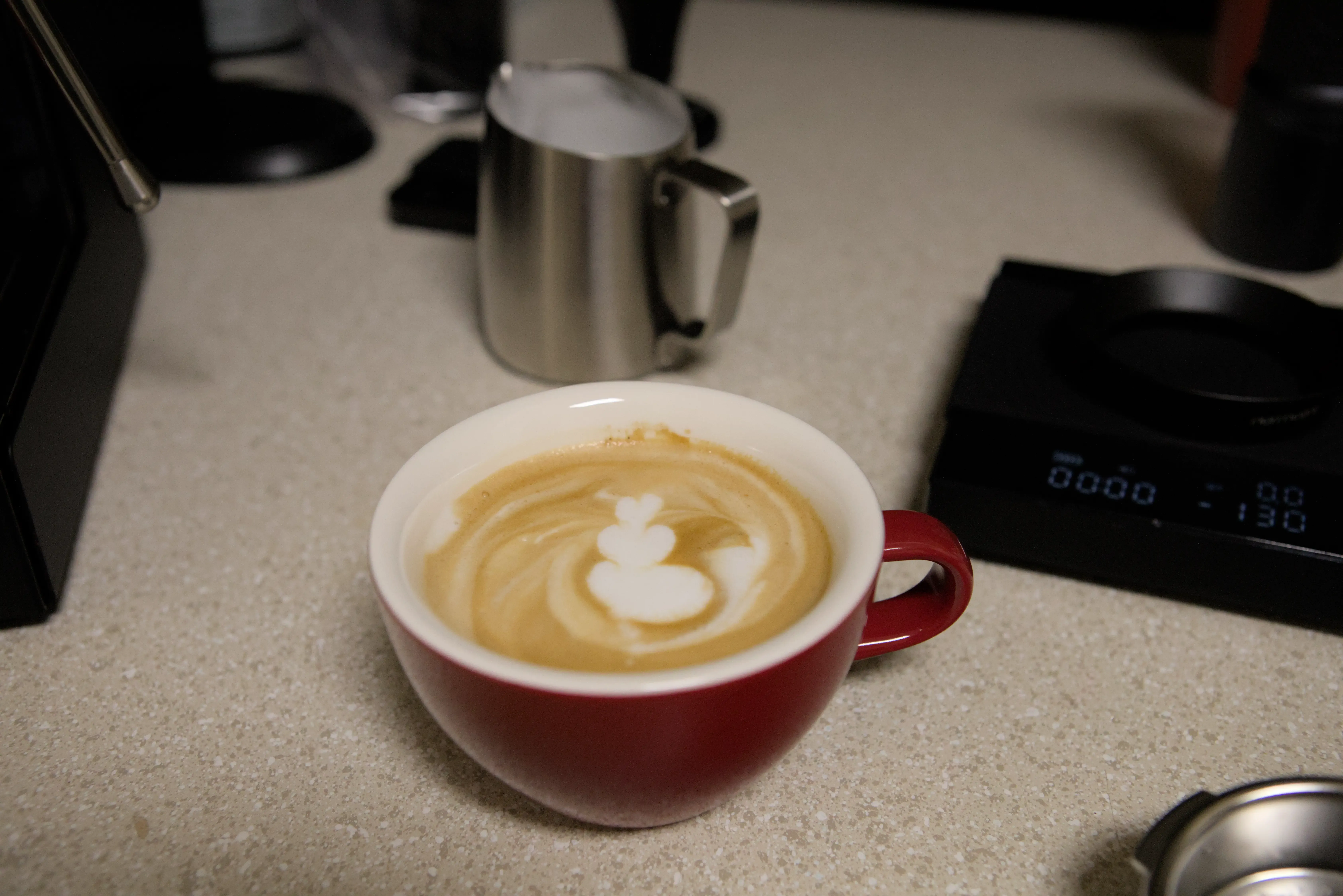 Latte with Scale to the left and Milk Pitcher behind
